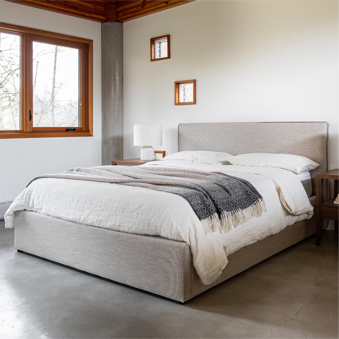 Bedroom with a large bed, side tables, and windows.
