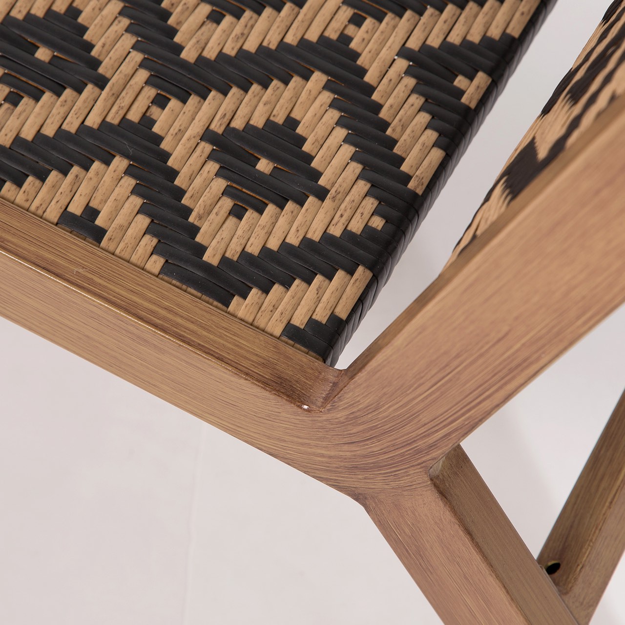 Close-up of a woven chair seat with a geometric pattern on a white background