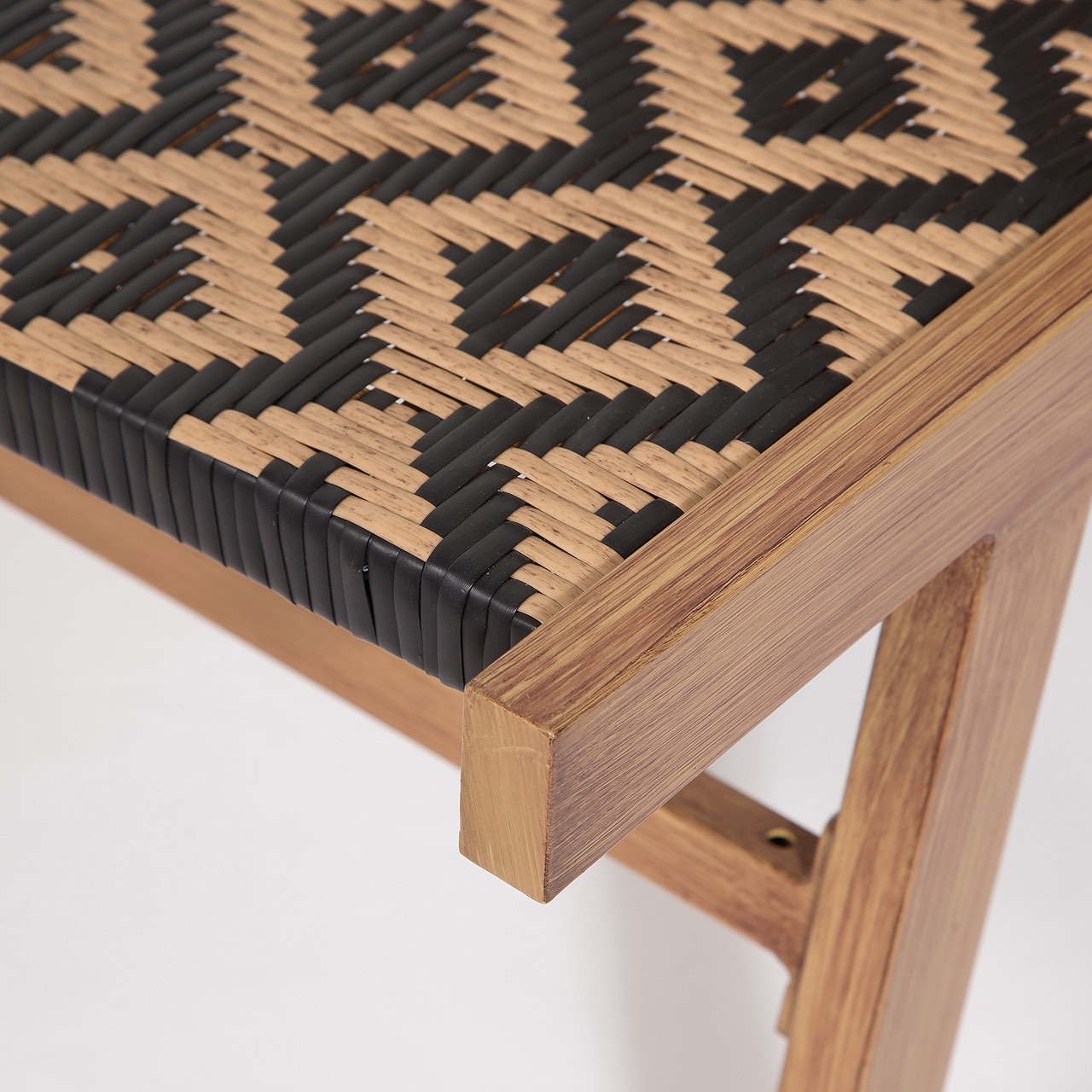 Close-up of a wooden stool with woven seat on a white background
