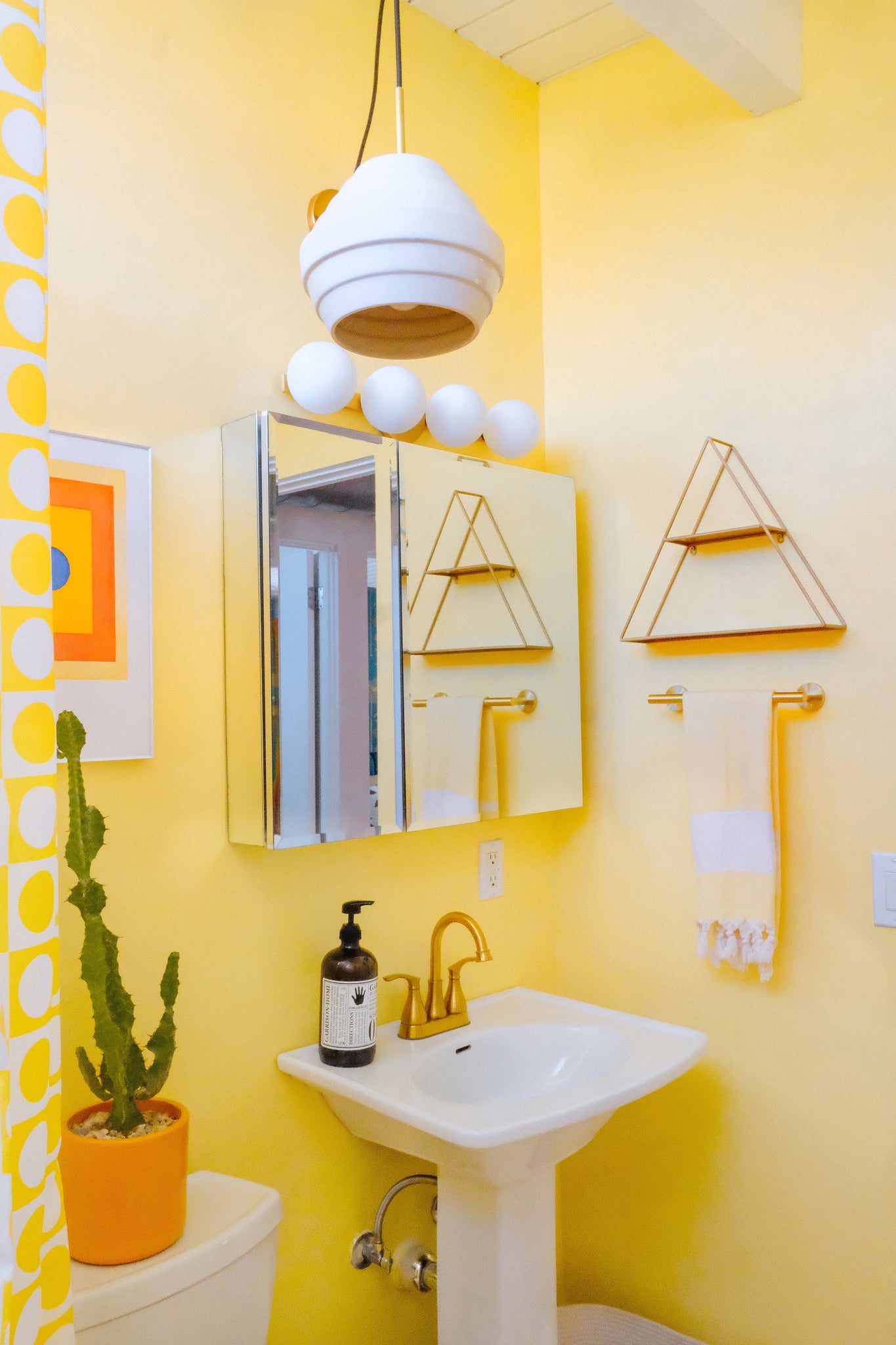 Close-up of the Baird Bath And Vanity 23.5" in aged brass showing the arm spread and shade silhouette.