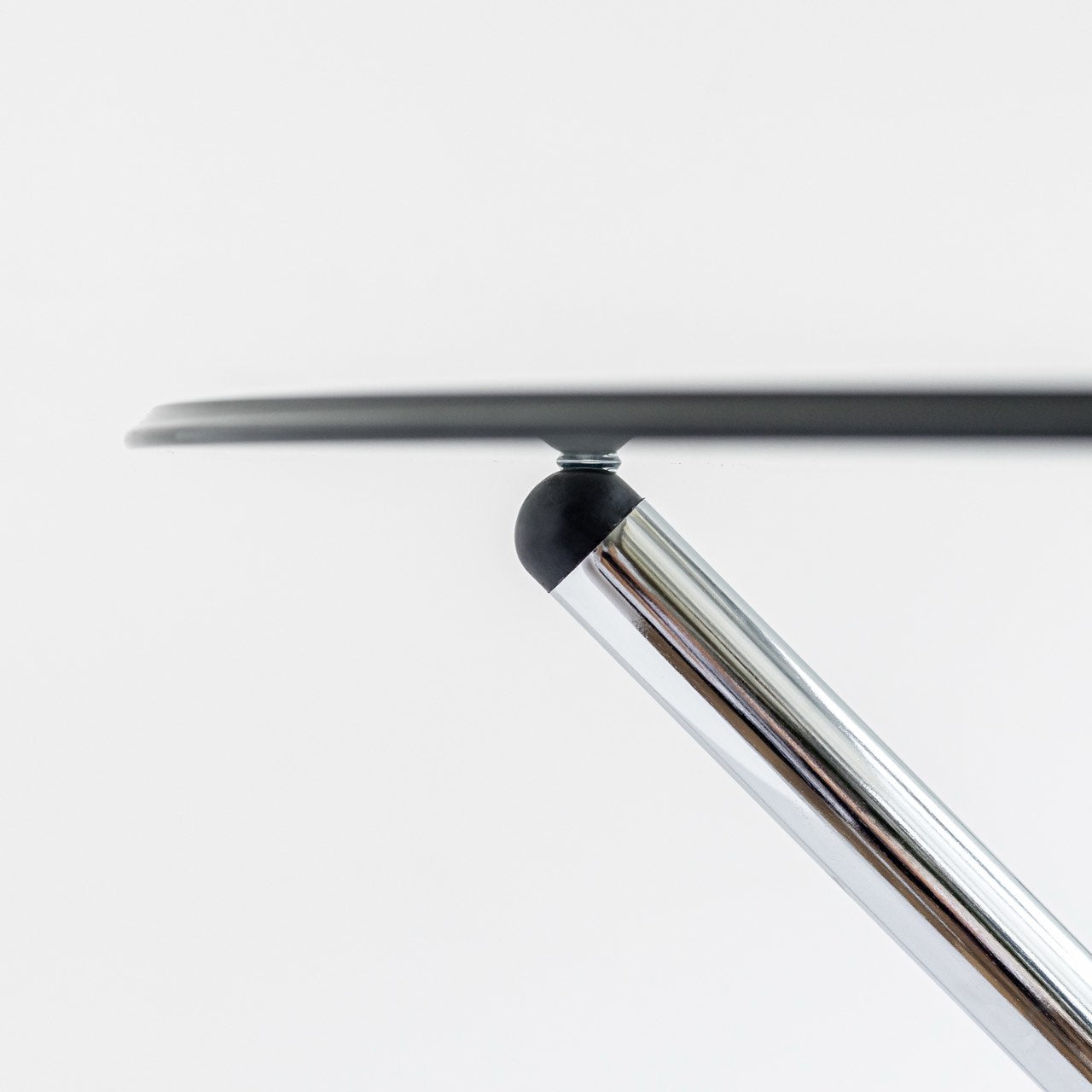 Close-up of a metallic chair leg with a white background