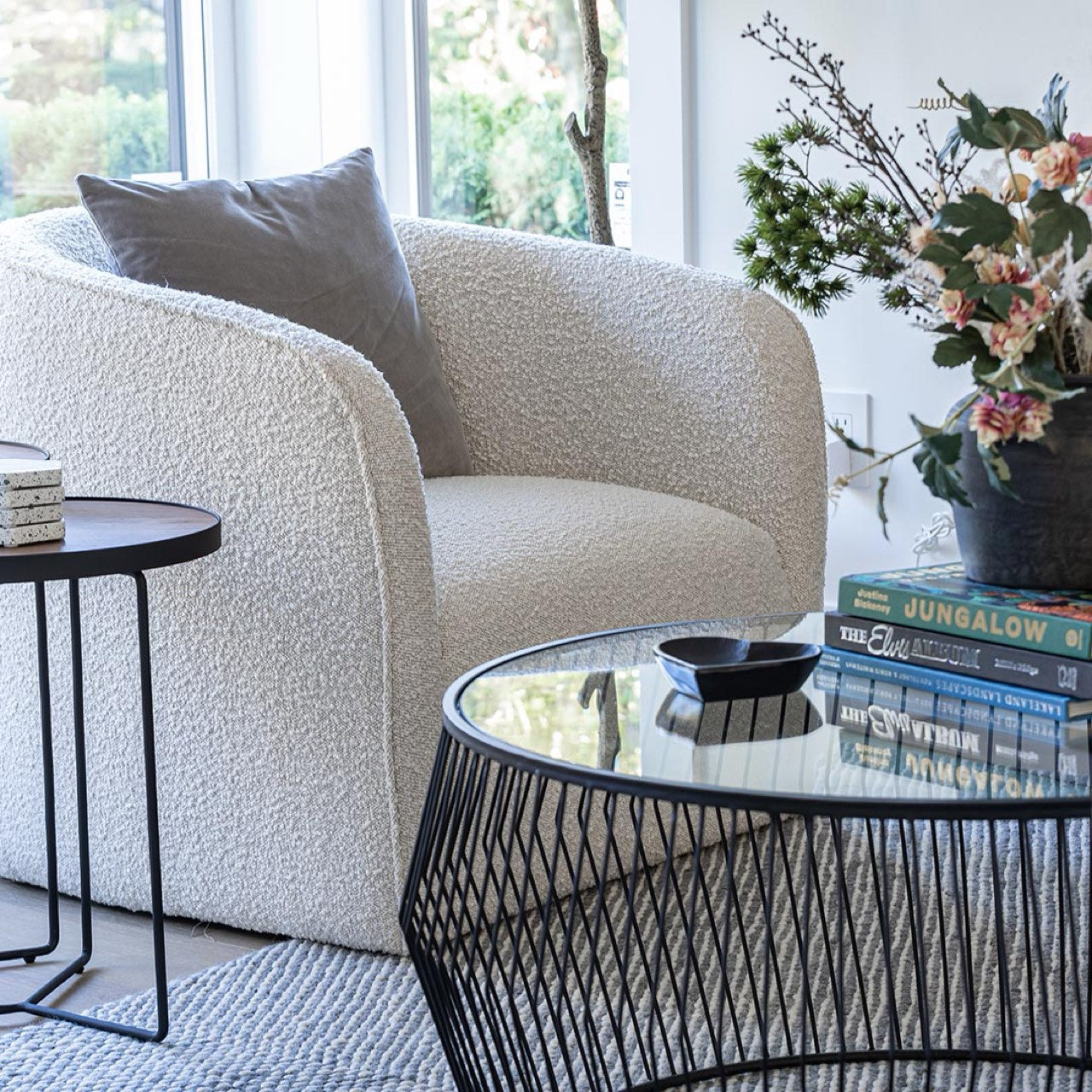 Modern living room with a textured armchair, glass coffee table, and decorative elements.