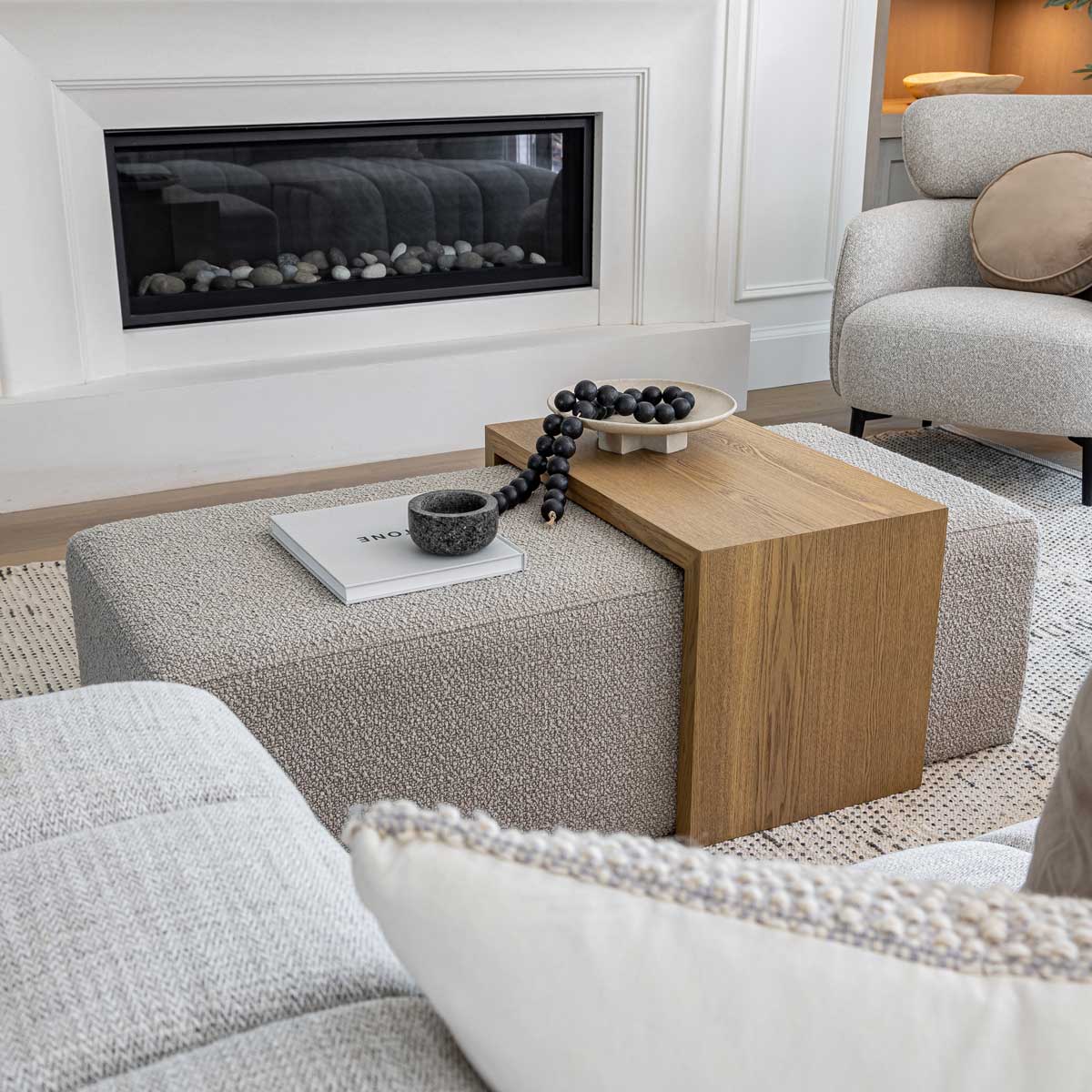 Living room with a fireplace, gray sofa, and wooden coffee table.