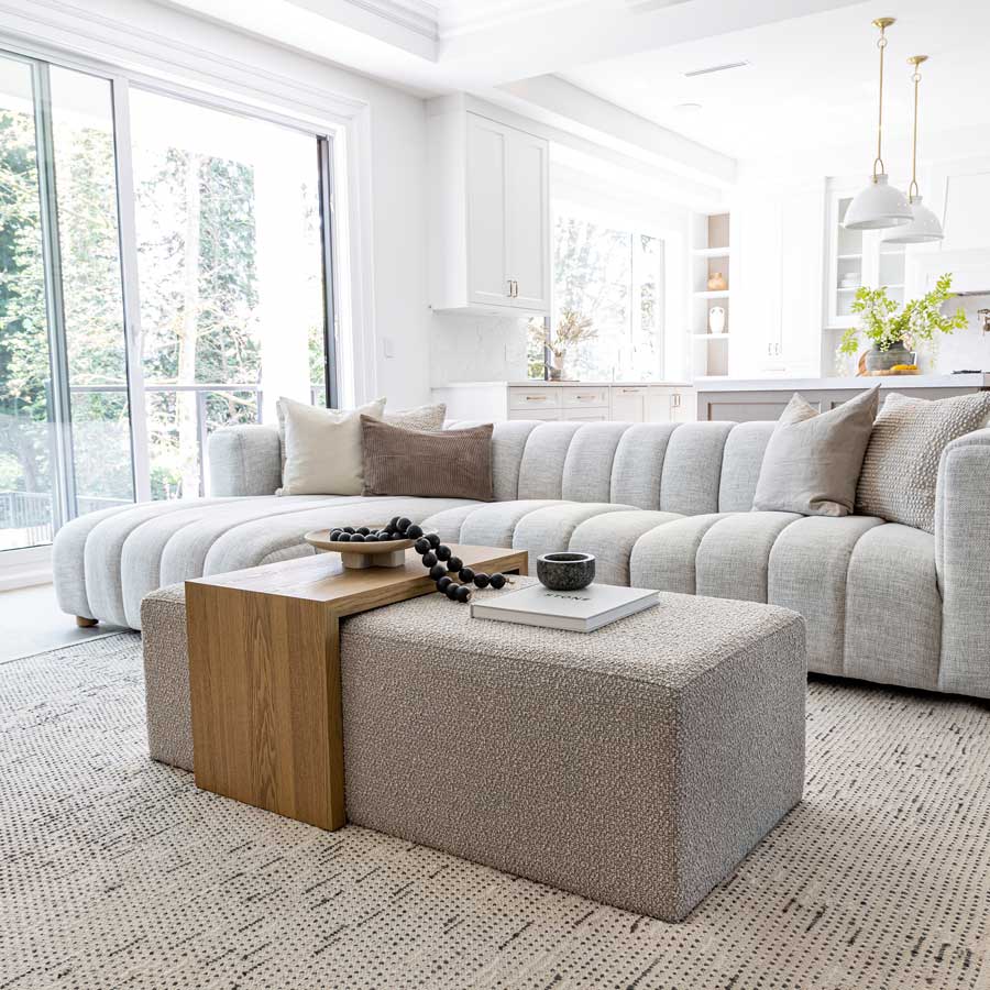 Modern living room with a gray sectional sofa, wooden coffee table, and decorative items.