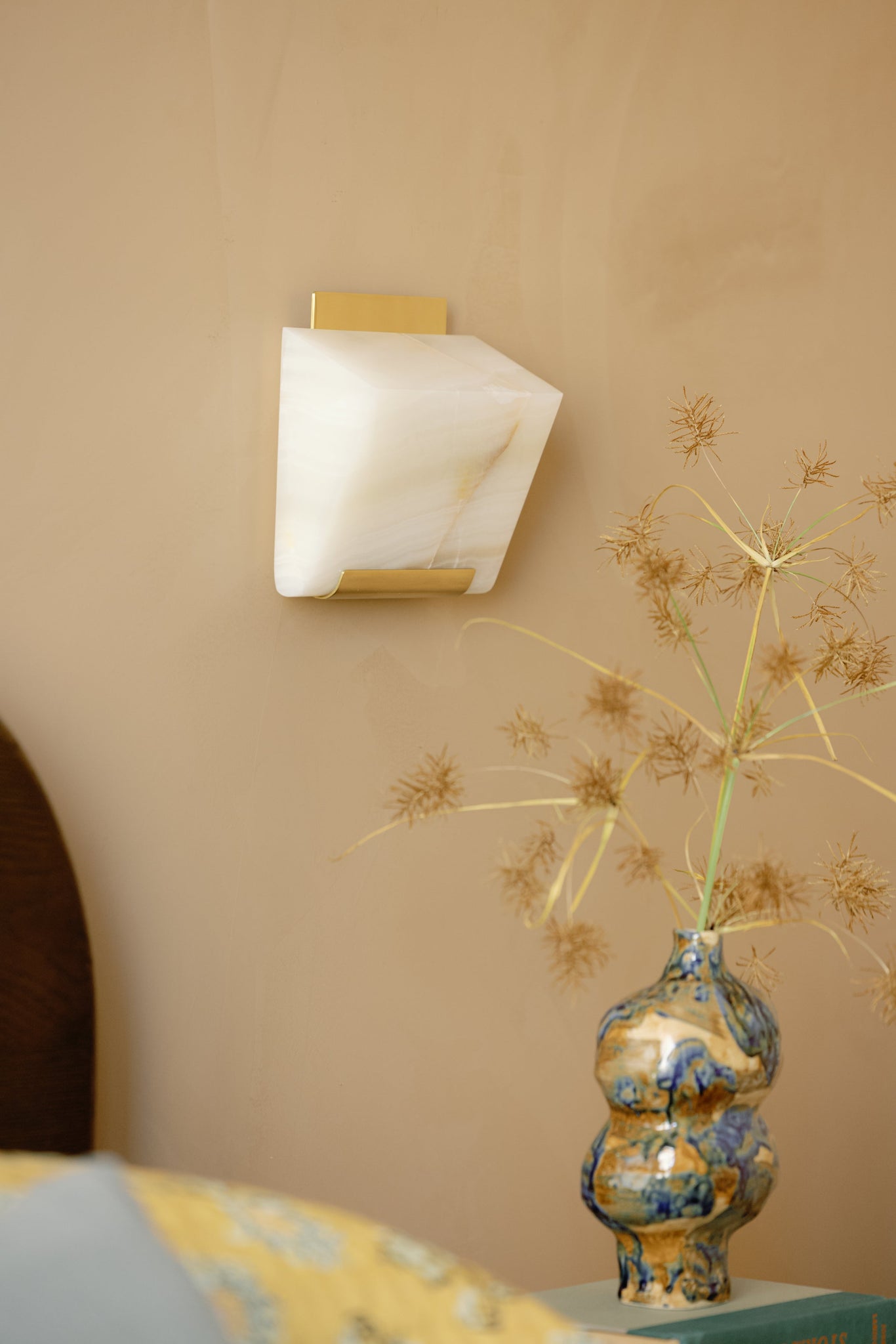 Fairfield Wall Sconce in aged brass styled in a modern bathroom for warm, layered light at Laurie Yapp Home.