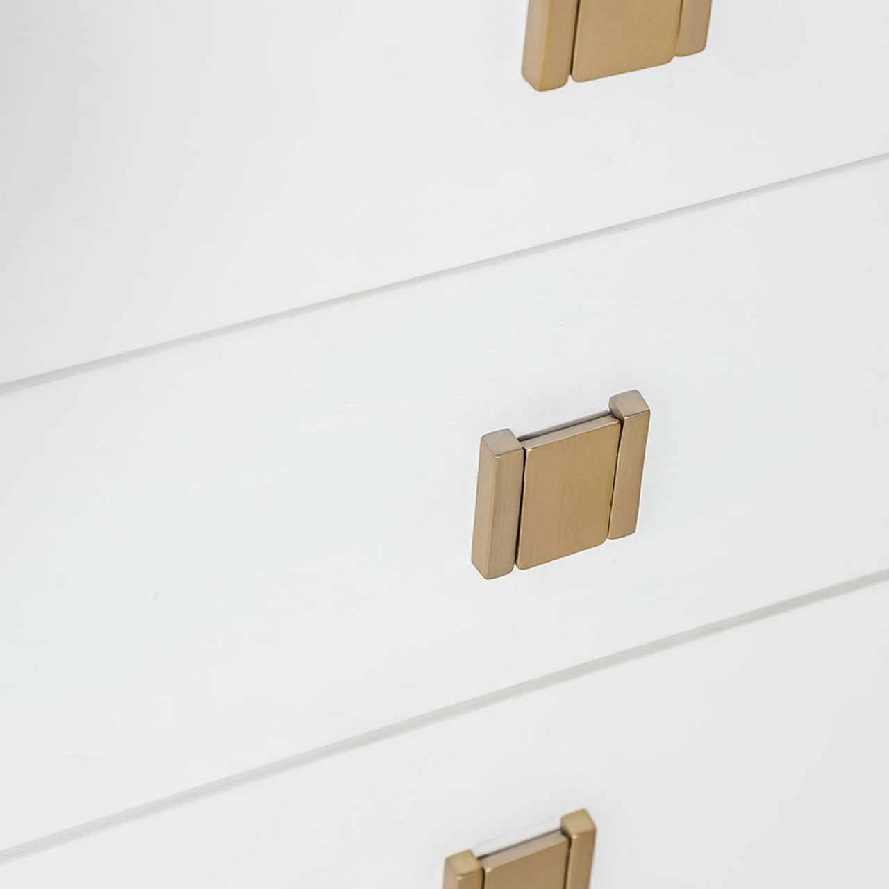 Gold cabinet handles on a white drawer