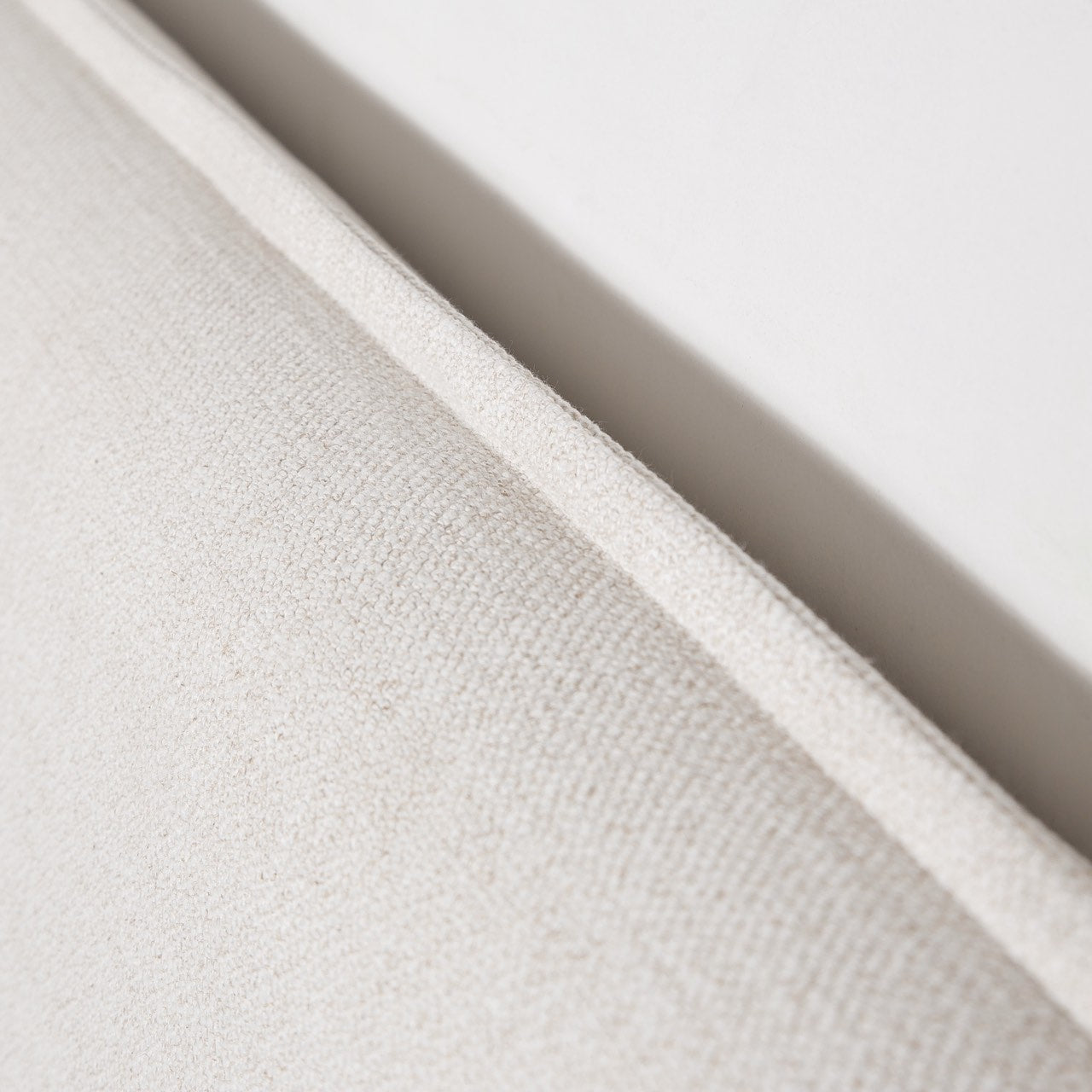 Close-up of textured beige fabric with a soft focus on a light background