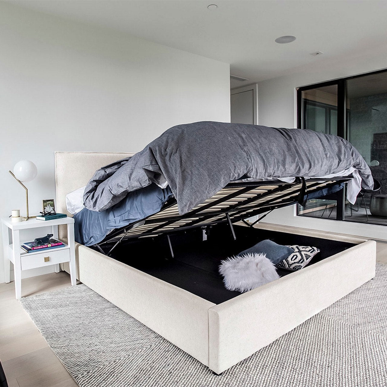 White bed with storage compartment in a modern bedroom setting