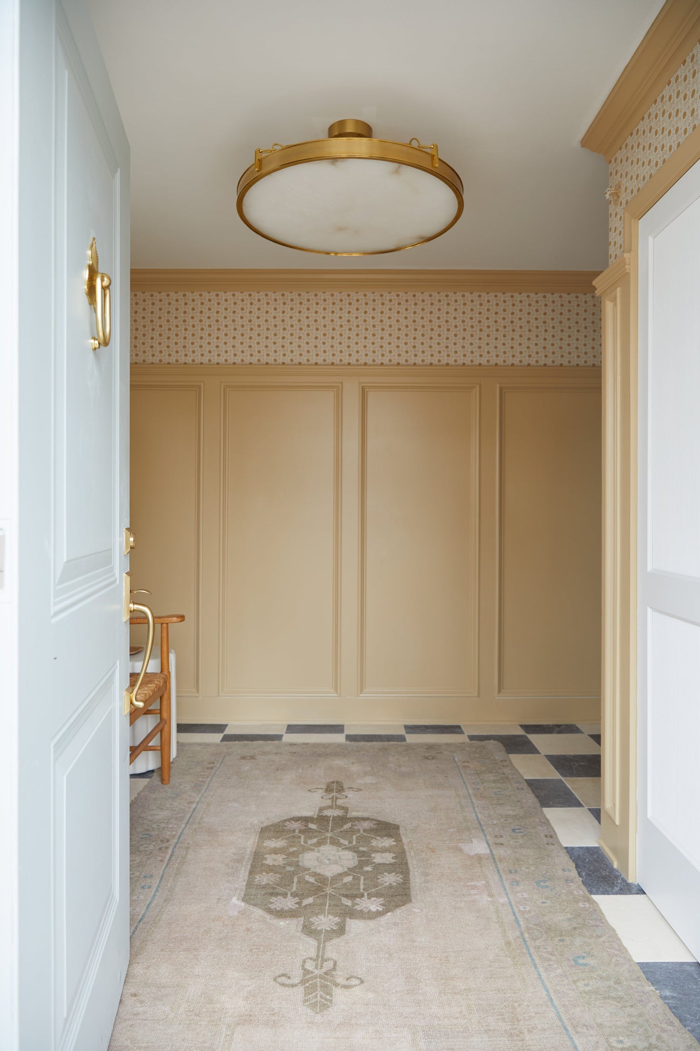 Kirby Chandelier 30" x 3.5" in aged brass styled in a formal living room for warm, layered light at Laurie Yapp Home.