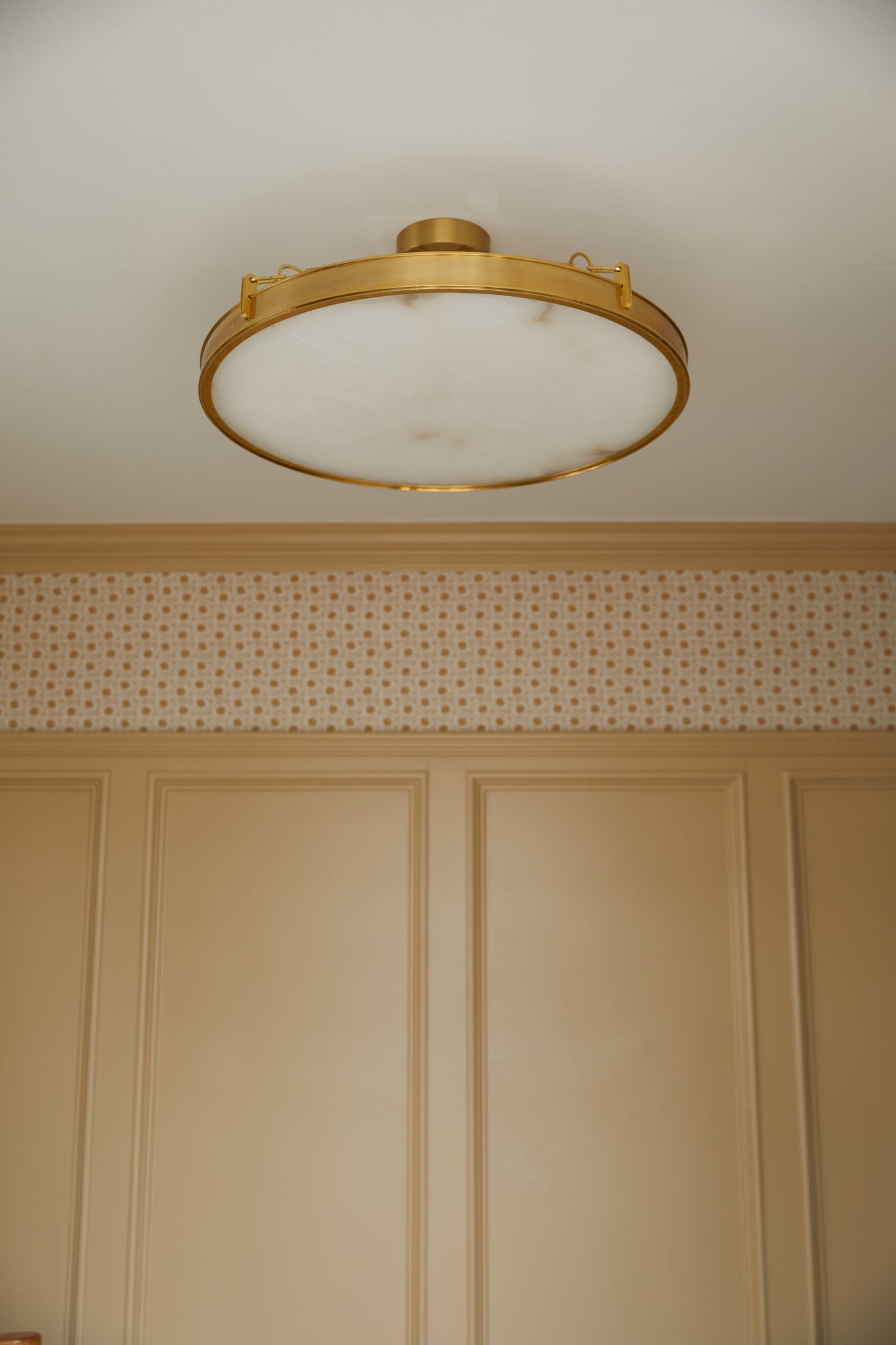 Kirby Chandelier 30" x 3.5" in aged brass styled in an elegant dining room for warm, layered light at Laurie Yapp Home.