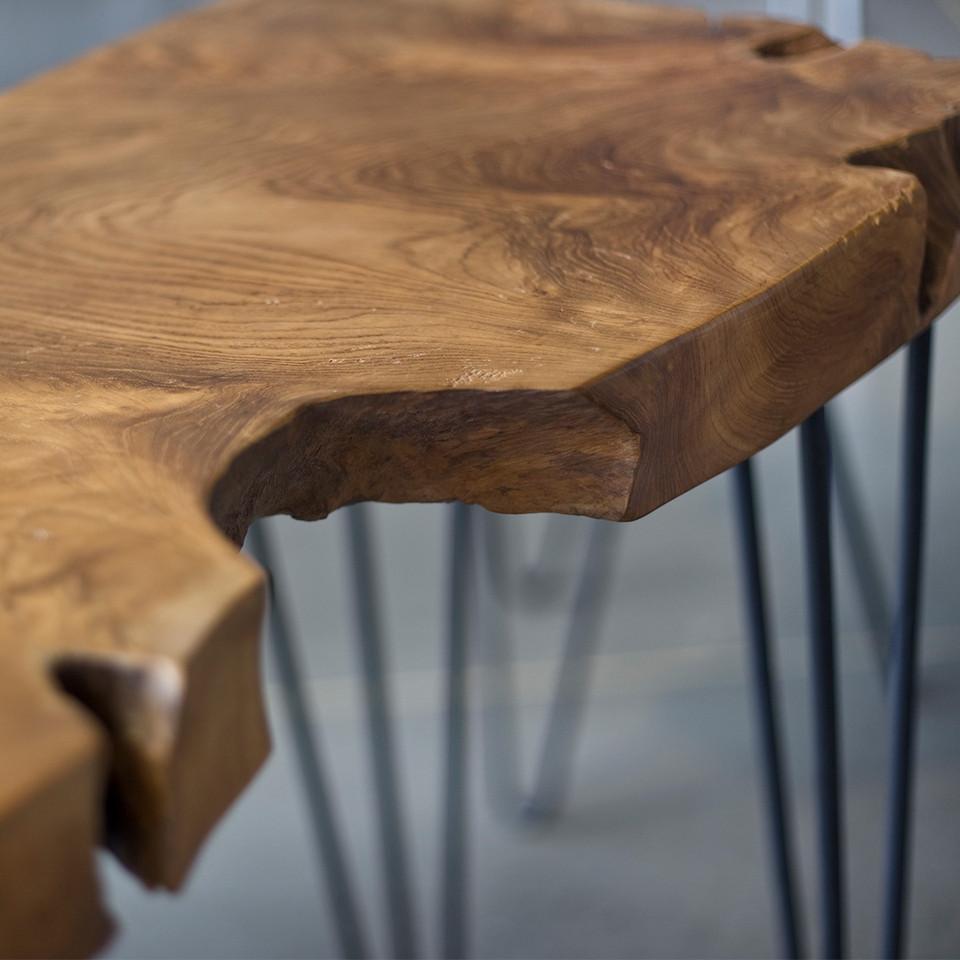 Wooden stool with a natural finish and metal legs on a blurred background