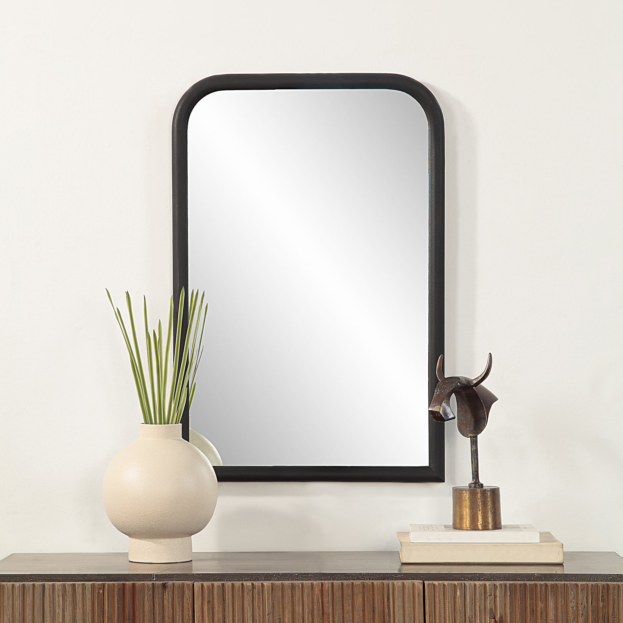 Dovima Wall Mirror displayed above a wooden console with decorative items.