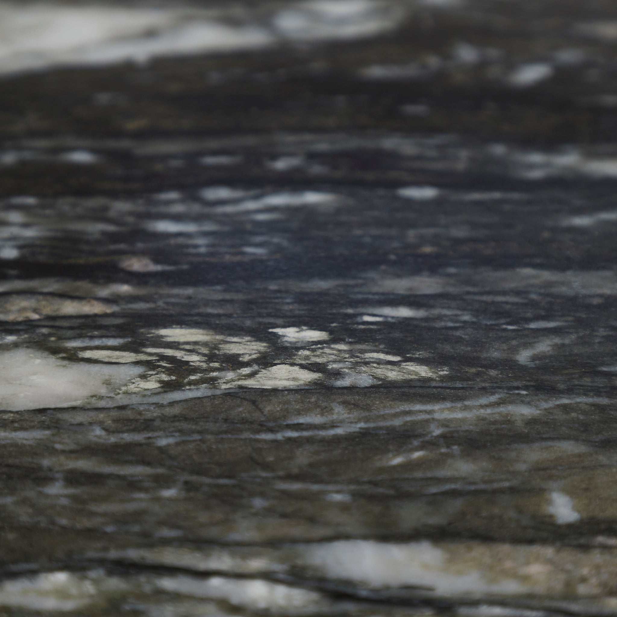 Detailed view of the black marble top of Adeline Side Table, emphasizing its natural patterns.