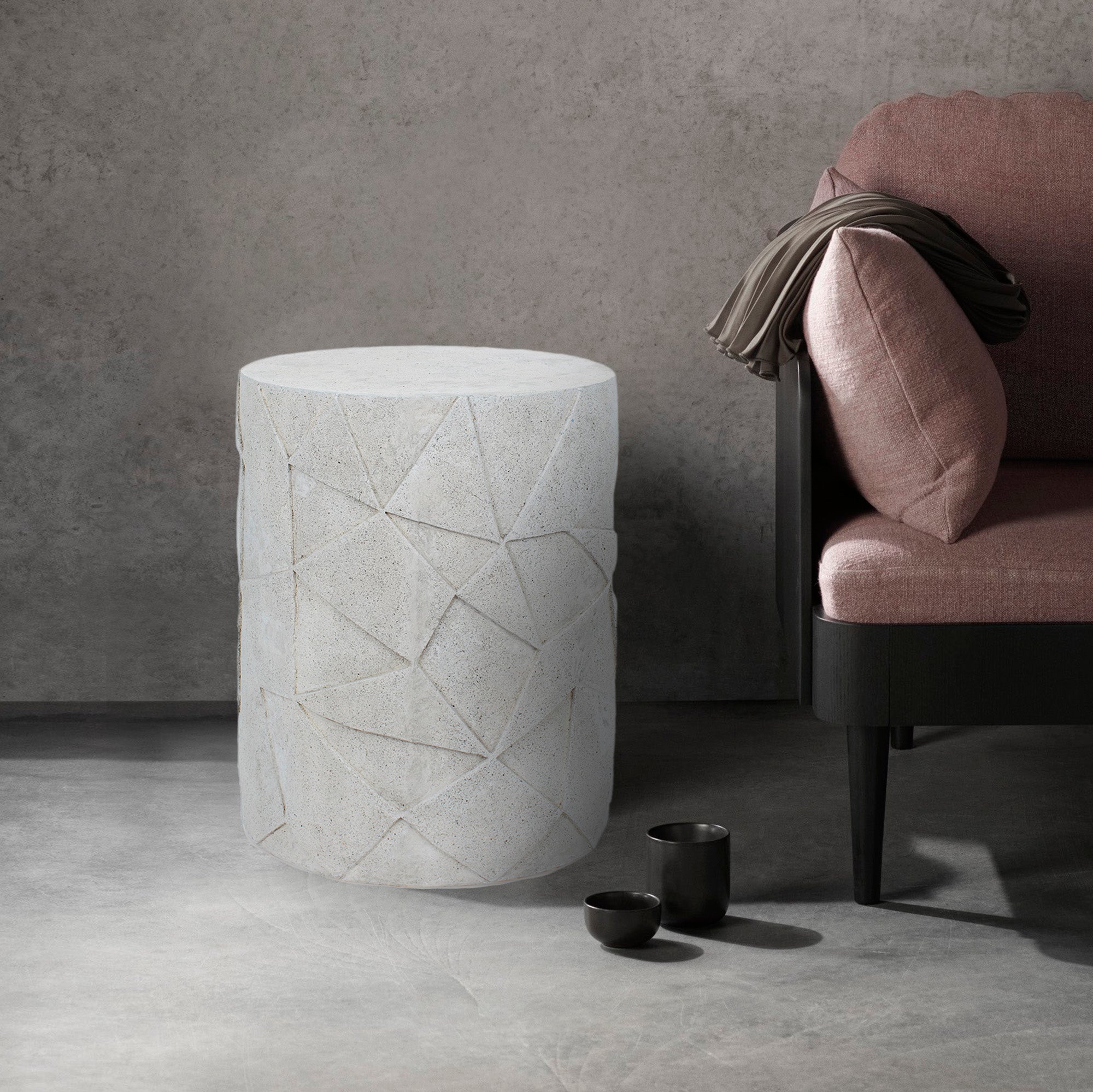 Nodin Side Table beside a modern sofa, featuring light gray concrete and geometric details