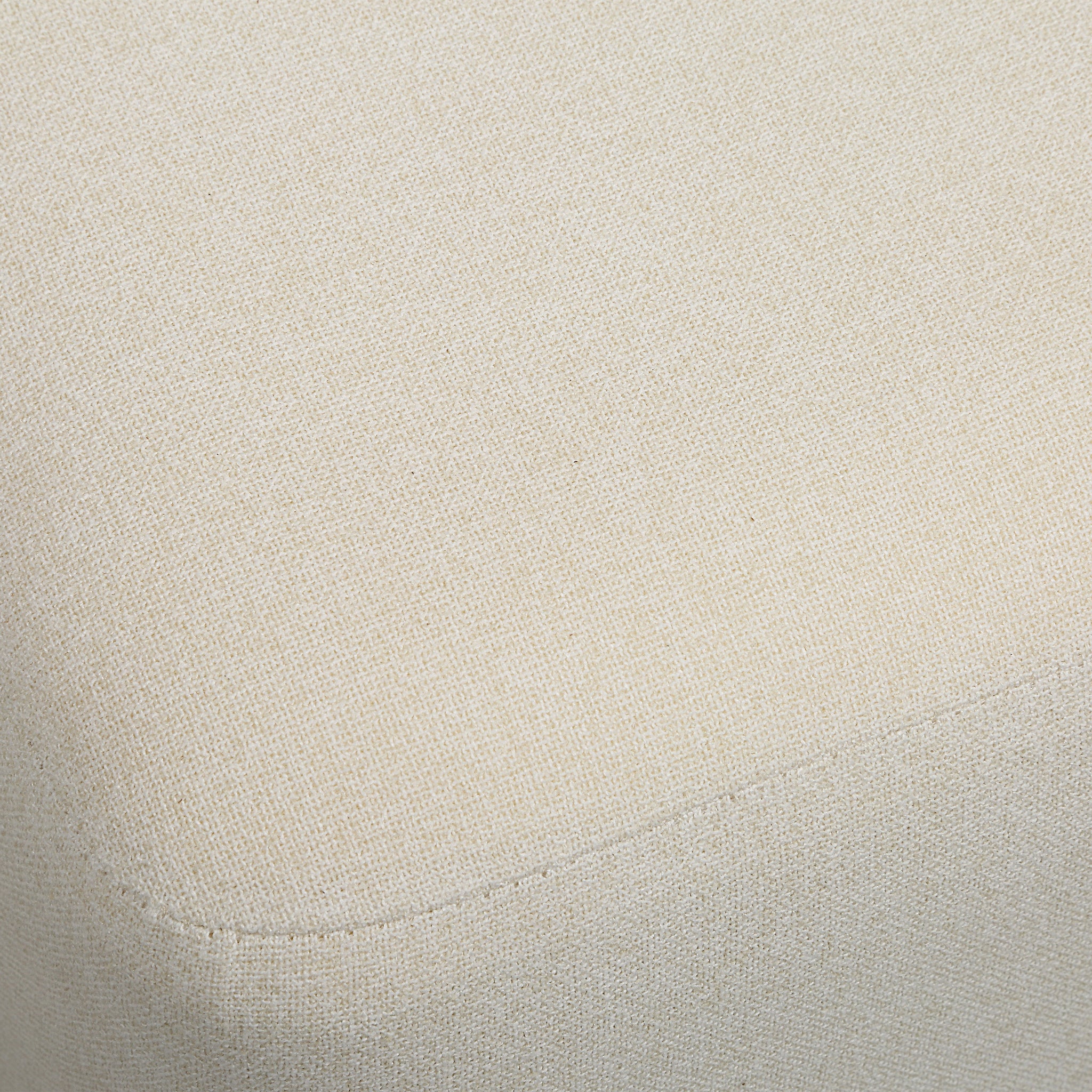 Sines ottoman in light beige fabric with a textured pattern and rounded edges, showcasing a close-up view of the upholstery.