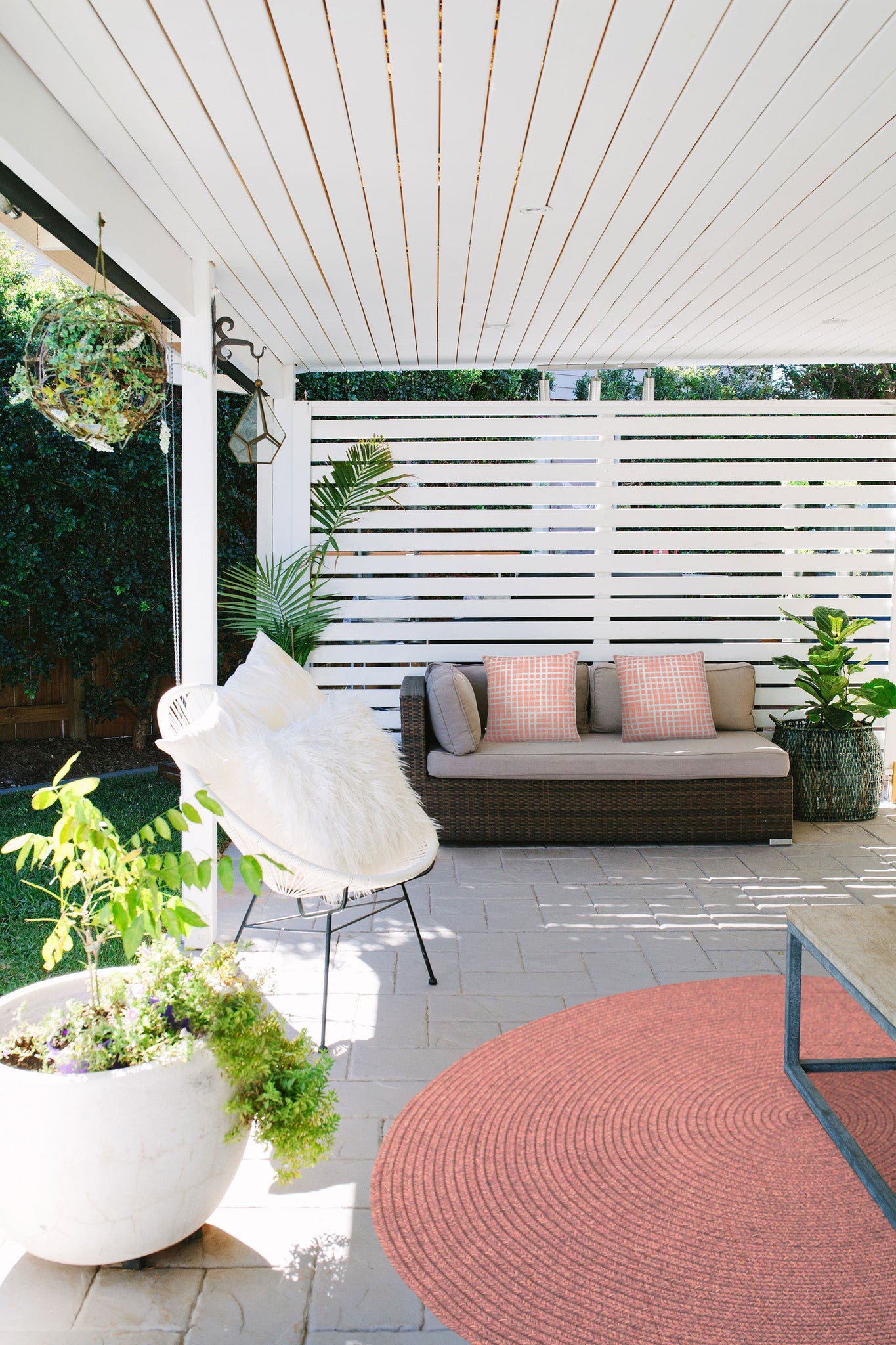 Outdoor setting featuring Morane Outdoor Pillows on a couch, surrounded by plants and decor.