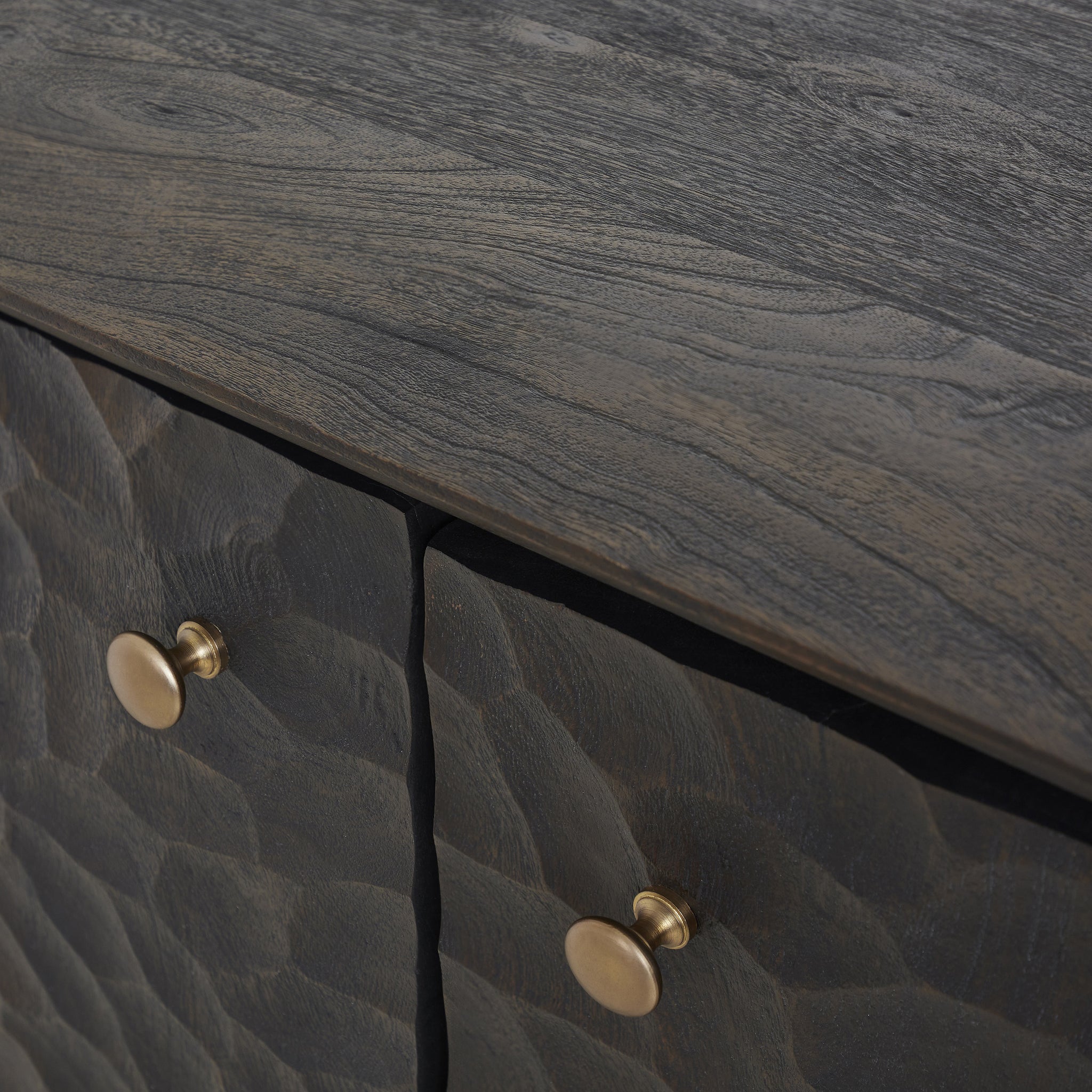 Close-up view of the Jean cabinet's textured surface and brass knobs.