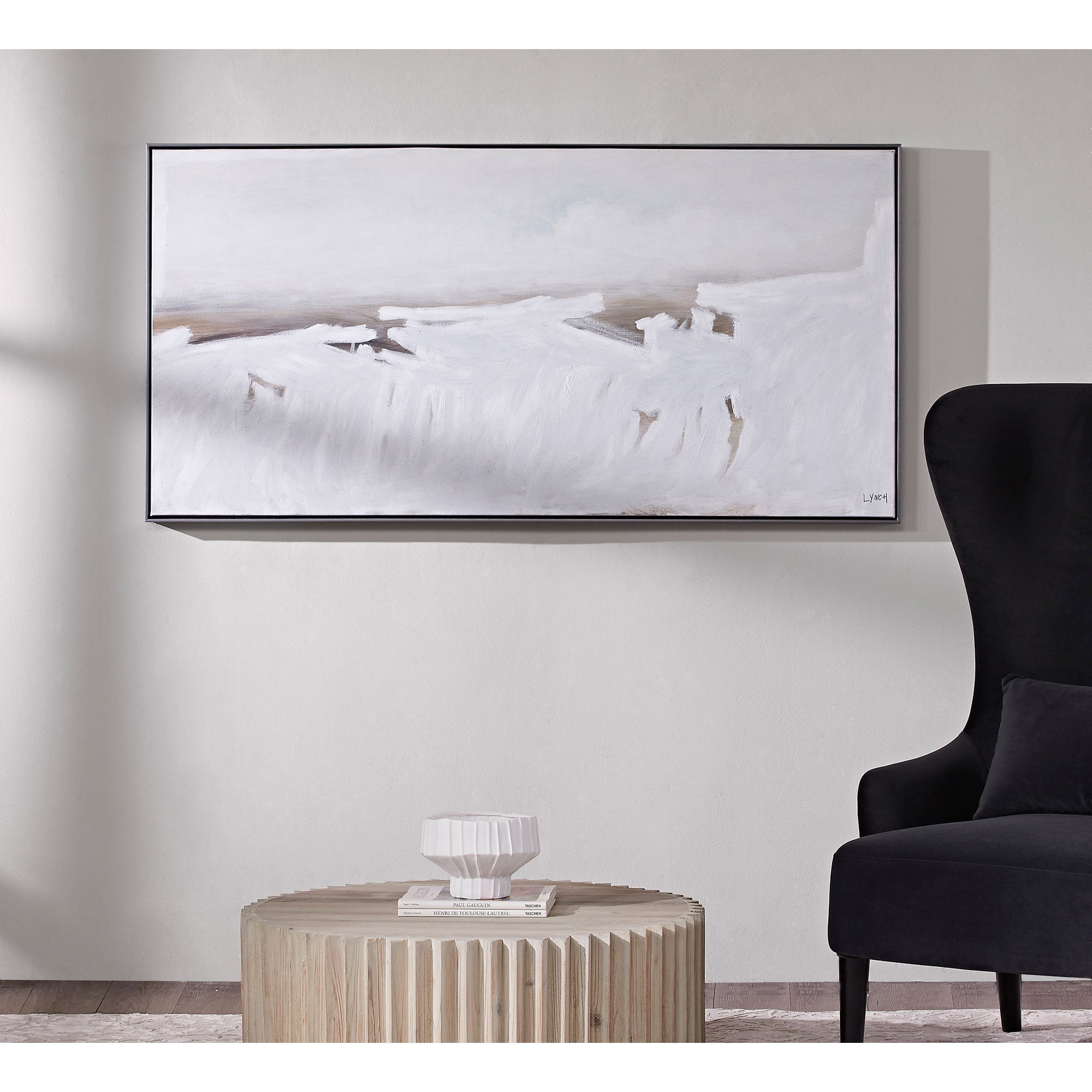 Blanche canvas art mounted on a wall above a round wooden table and black chair