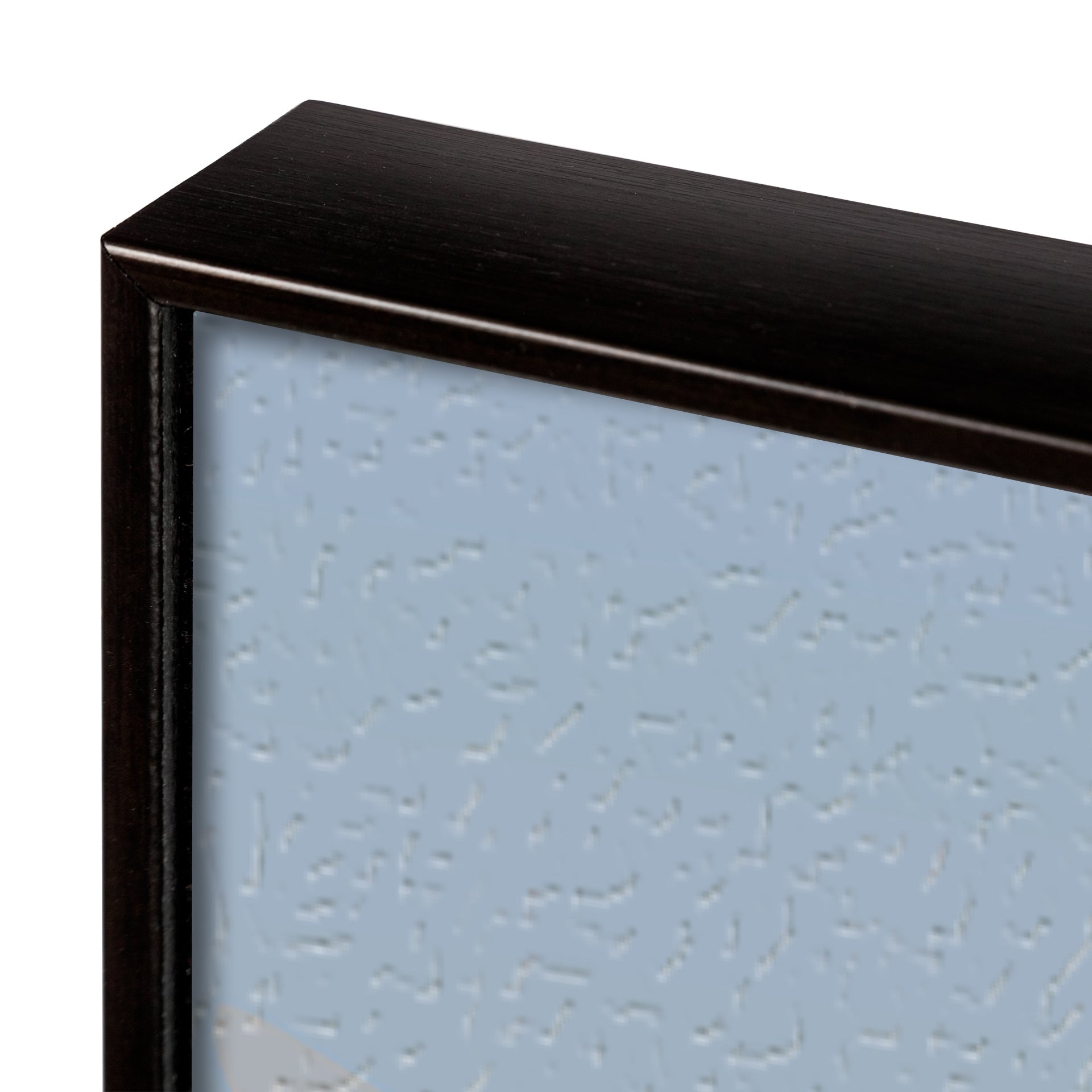 Close-up of a textured black frame corner with a light blue background