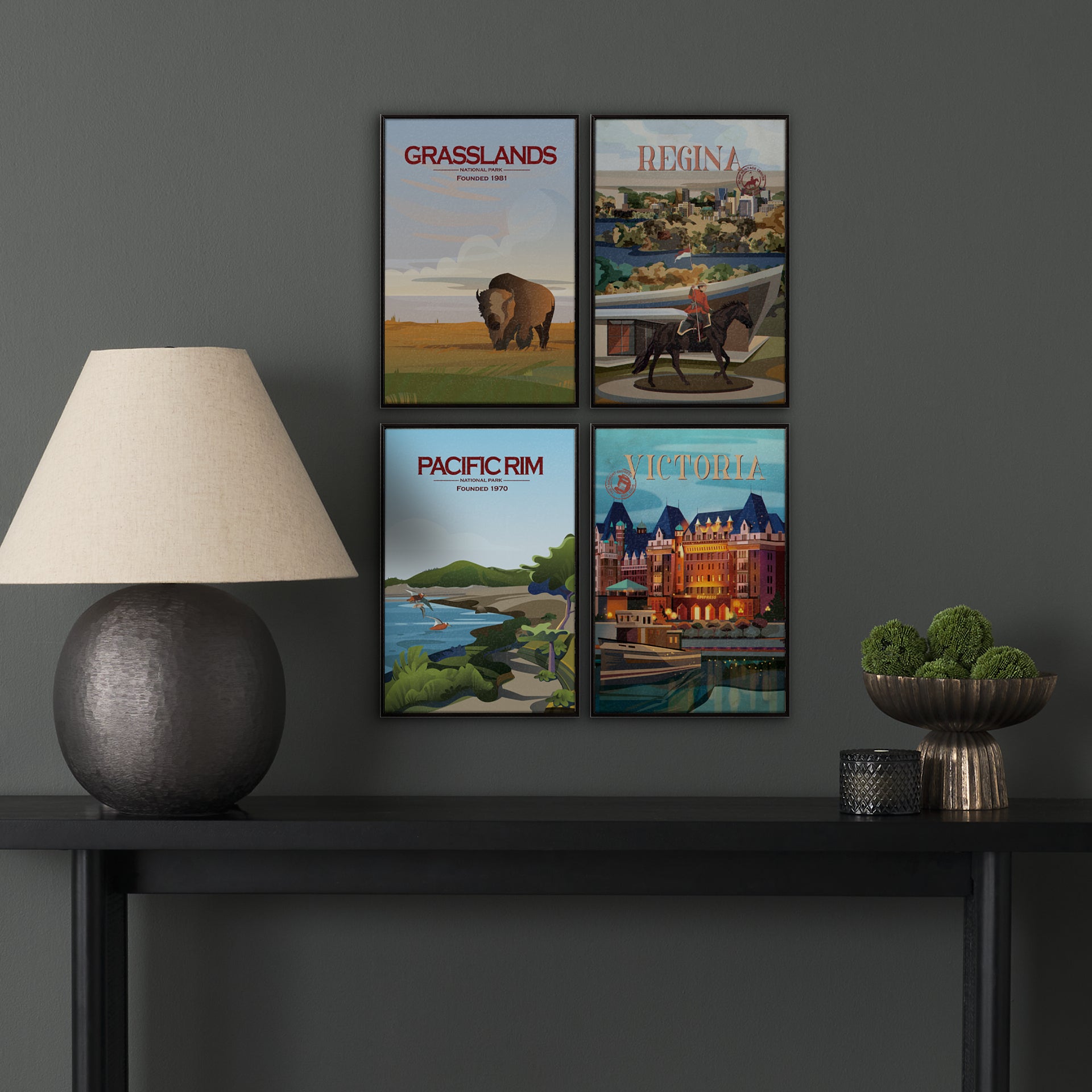 Four framed posters on a dark wall above a black table with decorative items.