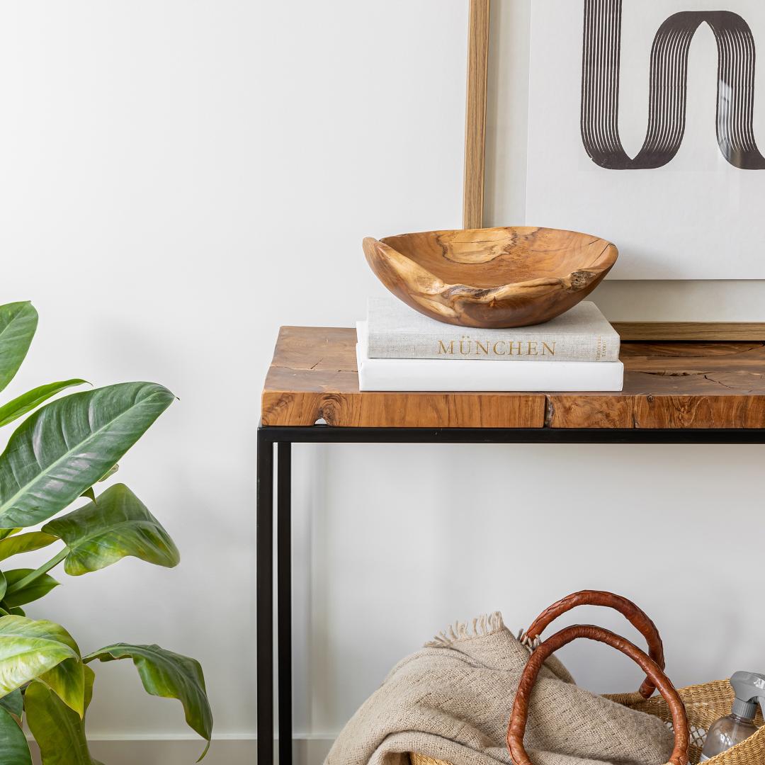 Wooden console table with decorative items against a white wall