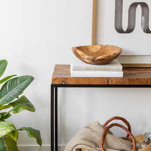 Wooden console table with decorative items against a white wall