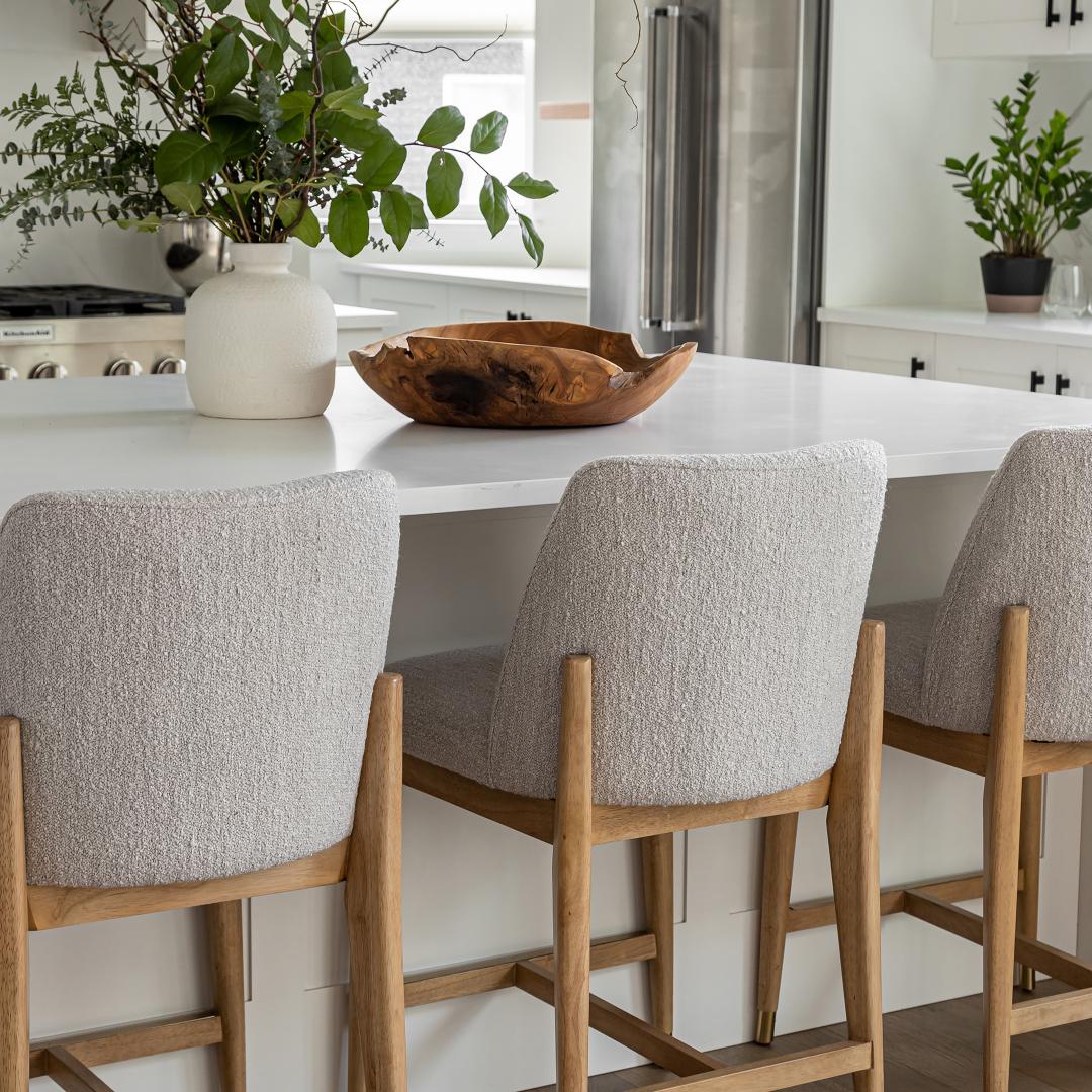 Kitchen with white island, bar stools, and decorative elements