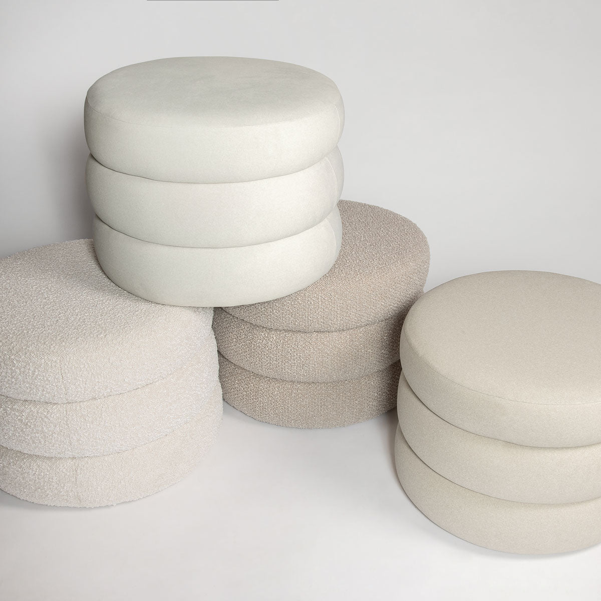 Round ottoman with stacked cylindrical design on a white background