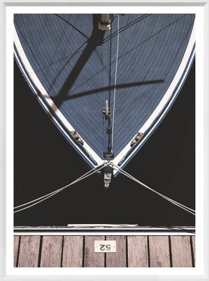 Slip '52' wall art featuring a top view of a blue boat and wooden dock.