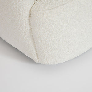 Close-up of a textured white cushion on a light gray background