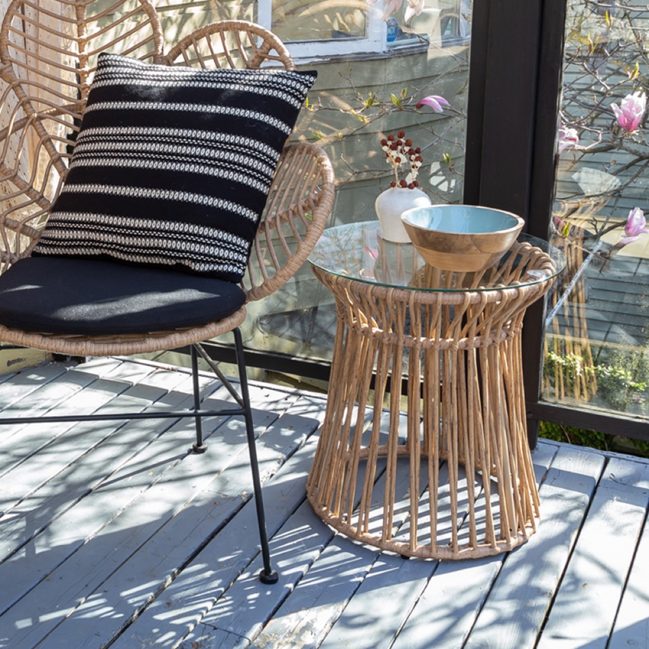 Wicker side table with glass top on a white background