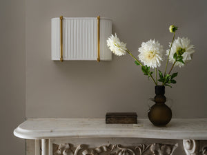 Cornell Wall Sconce 12" in aged brass styled in a modern bathroom for warm, layered light at Laurie Yapp Home.