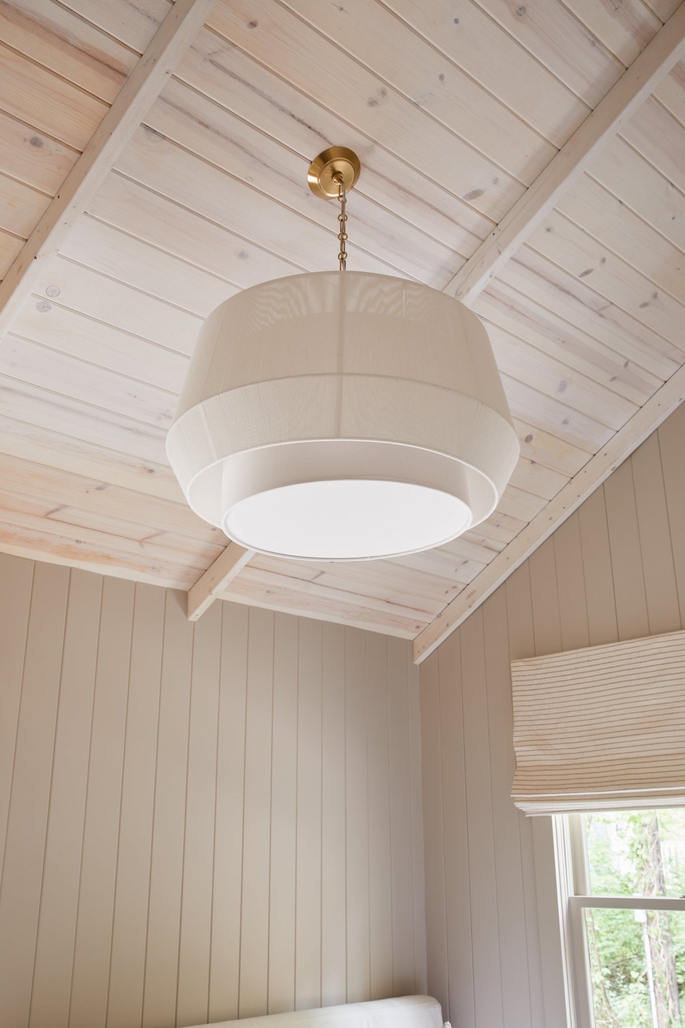 Debi Pendant 30.5" in aged brass styled in a welcoming entryway for warm, layered light at Laurie Yapp Home.