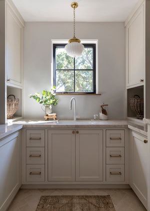 Dutchess Pendant 12" in aged brass styled in a welcoming entryway for warm, layered light at Laurie Yapp Home.