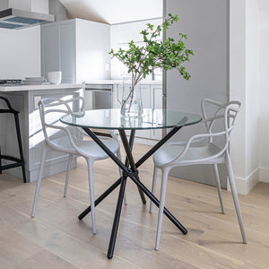 Modern kitchen with a glass dining table and white chairs.