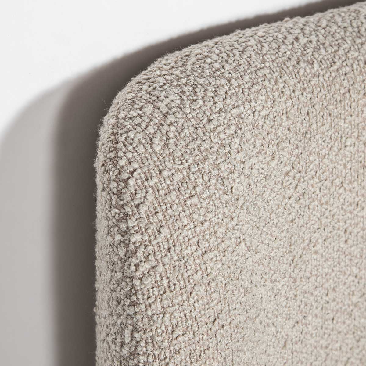 Truffle upholstered bed with white bedding on a white background