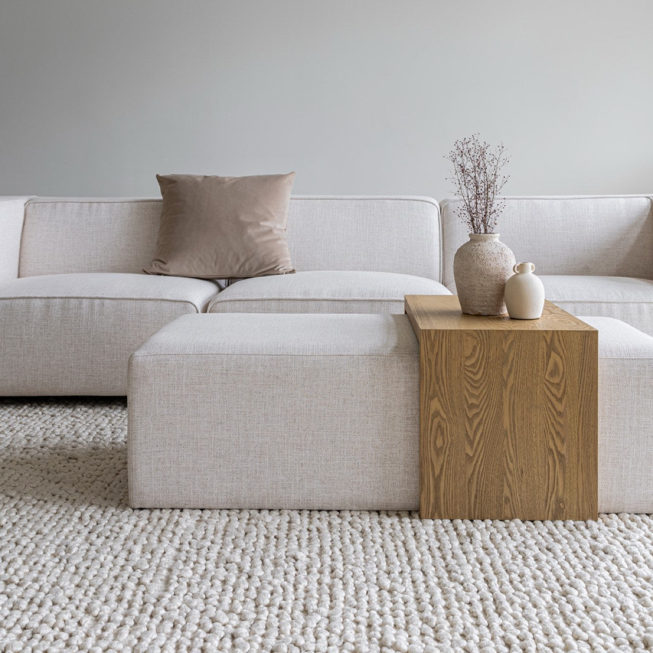 Two rectangular ottomans, one with wooden finish and the other with white fabric, on a white background.