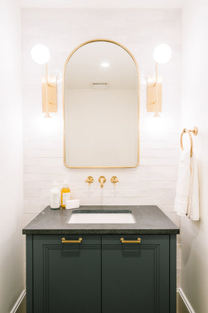 Fleming Wall Sconce in aged brass styled in a curated living room for warm, layered light at Laurie Yapp Home.