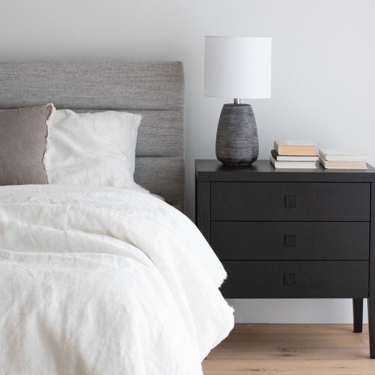 Black three-drawer dresser on a white background