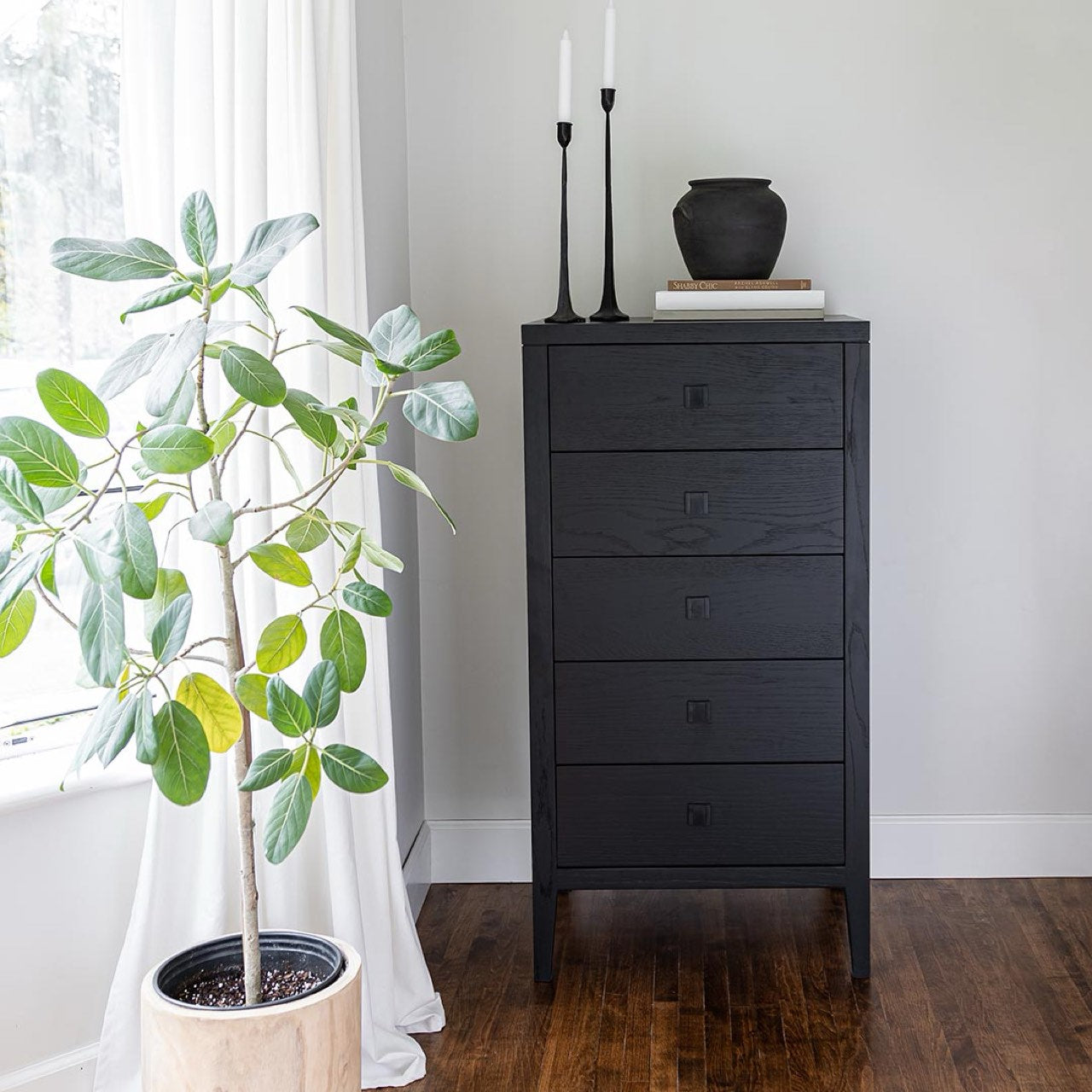 Dark wood dresser with four drawers on a white background