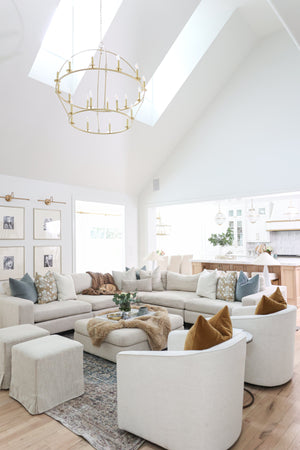Howell Chandelier 47" x 42.25" in aged brass styled in a two-story entry for warm, layered light at Laurie Yapp Home.