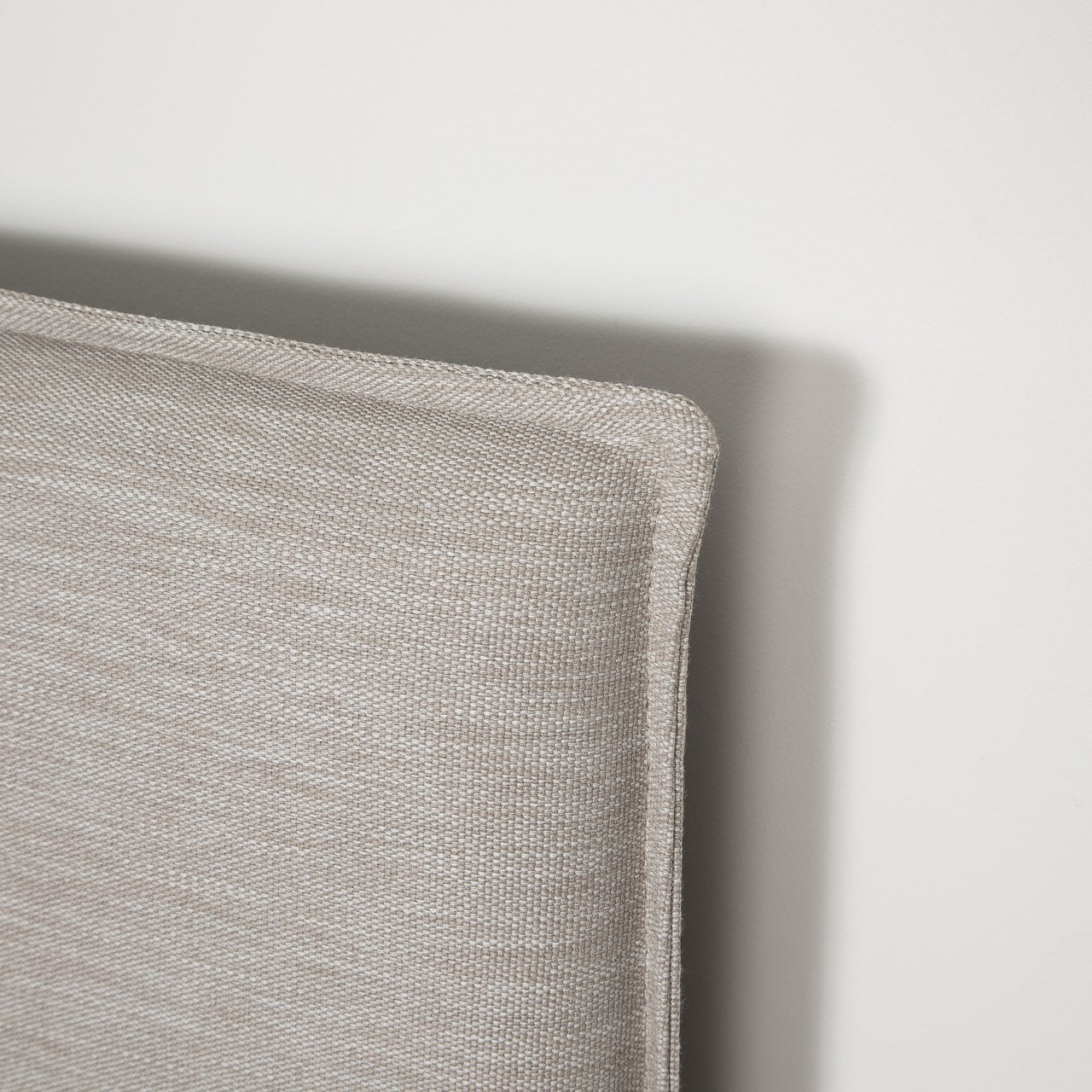 Gray upholstered bed with white mattress on a white background