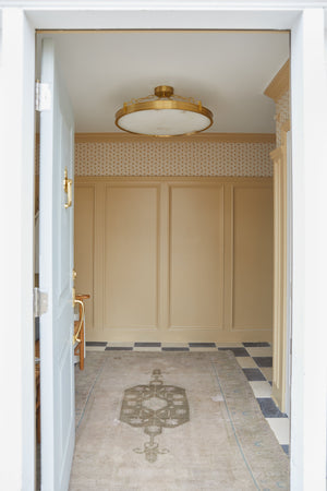 Kirby Chandelier 30" x 3.5" in aged brass styled in a two-story entry for warm, layered light at Laurie Yapp Home.