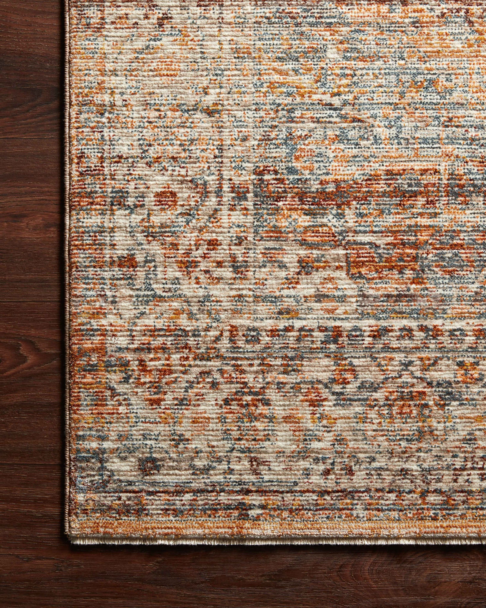 side view of Lourdes Tangerine / Ocean luxury Rug