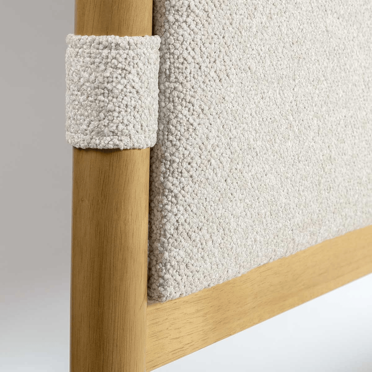 Close-up of a wooden bed frame with textured headboard
