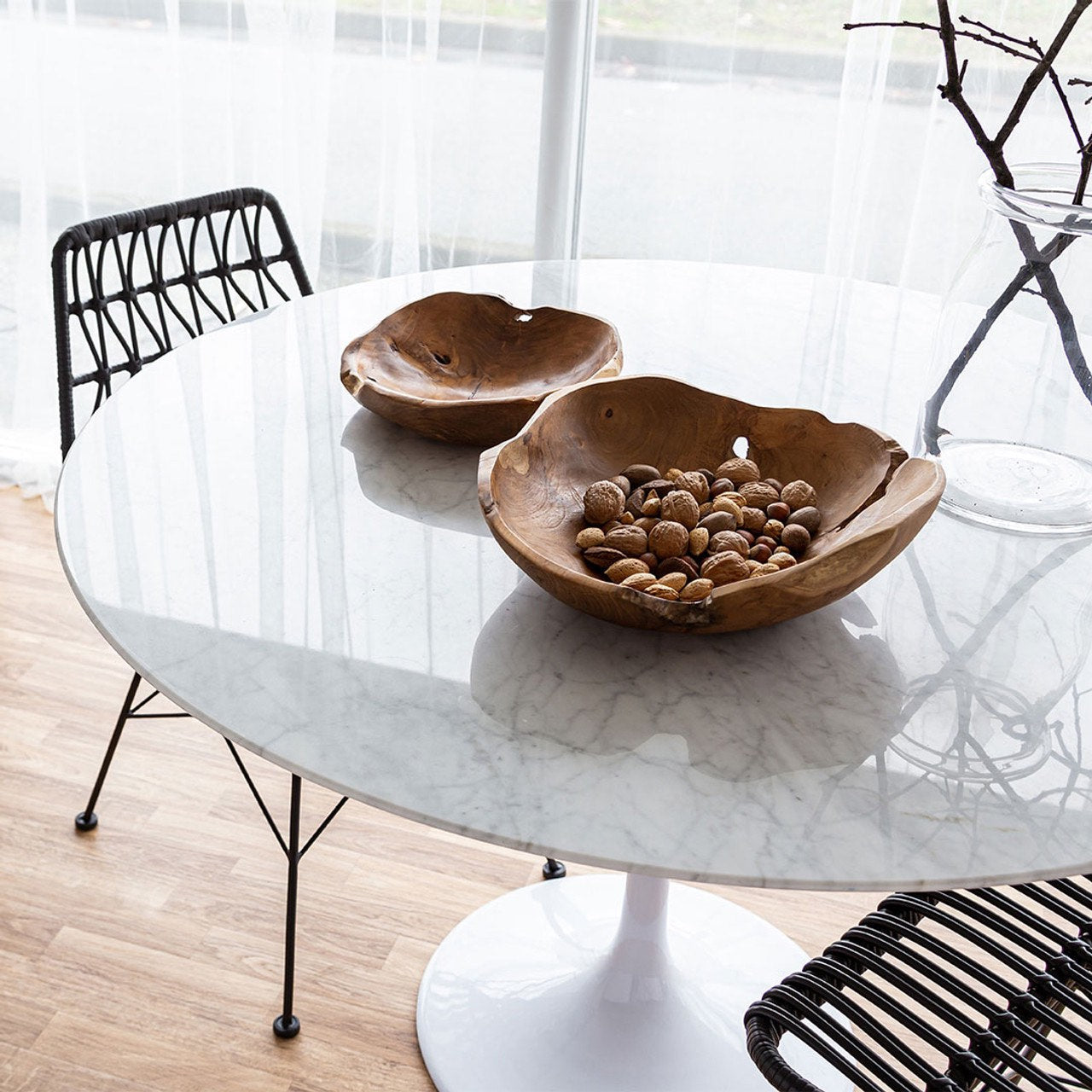 Wooden bowls on a marble coffee table with chairs around