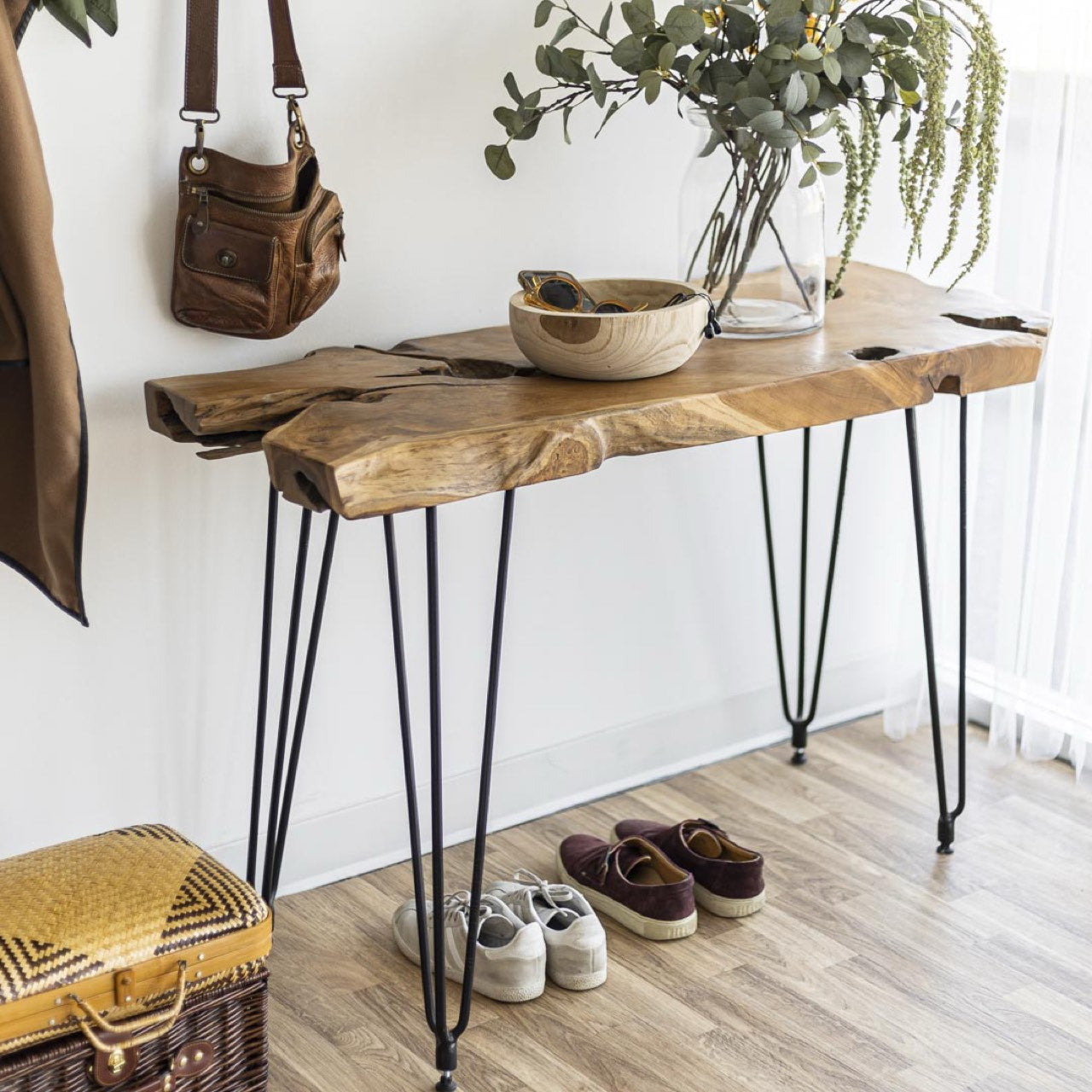 Wooden console table with hairpin legs in a room setting with shoes, basket, and decor items.