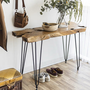 Wooden console table with hairpin legs in a room setting with shoes, basket, and decor items.