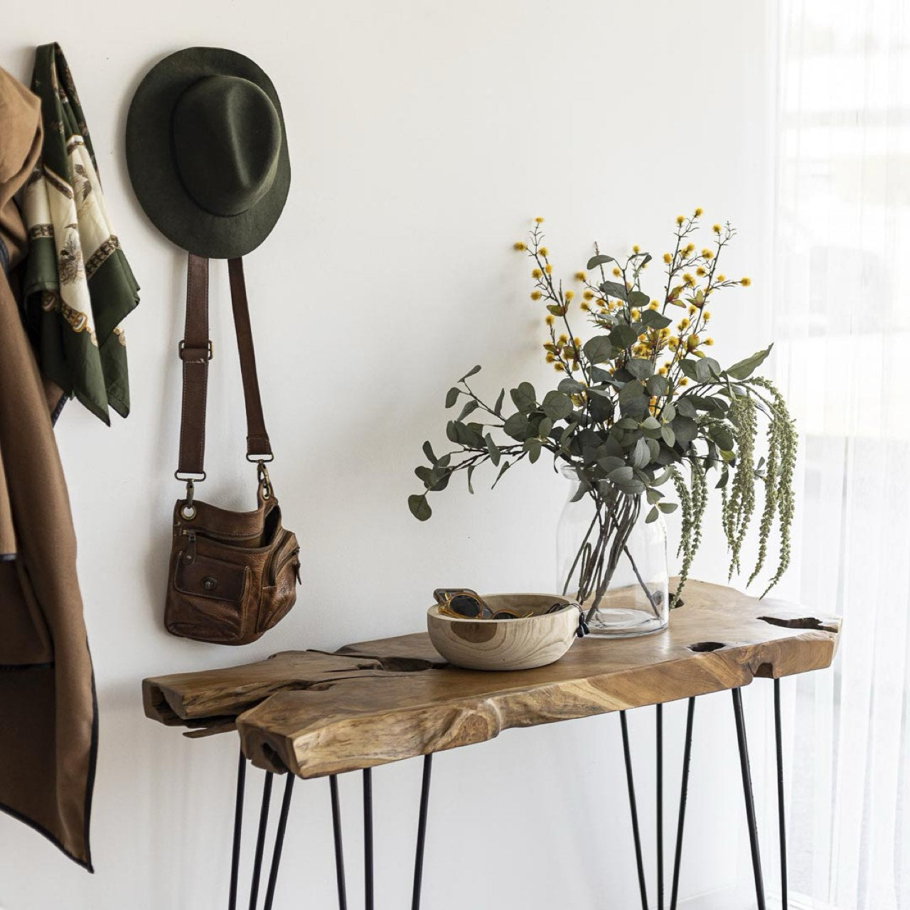 Wooden console table with decorative items against a white wall