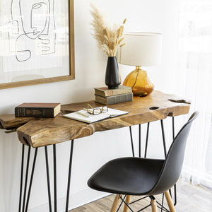 Wooden console table with black chair against a white wall